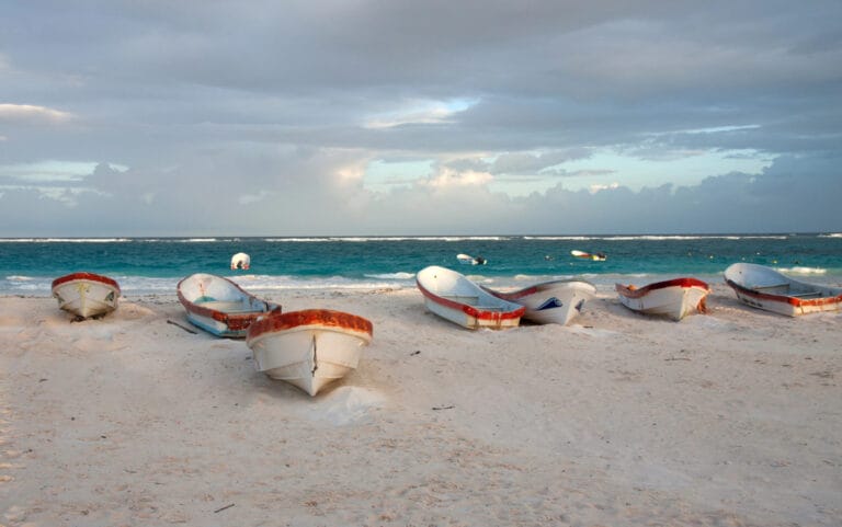 boat on the shore of a beach and a cloudy sky