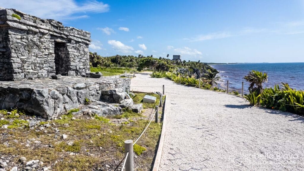 Ancient ruins by the sea under clear blue sky.
