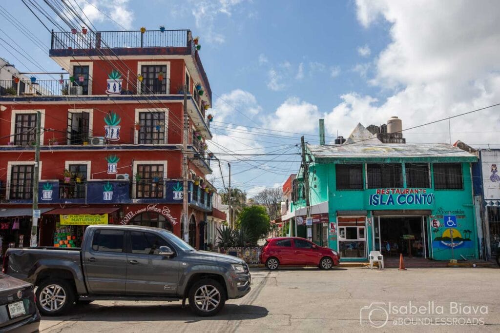 Colorful street scene with buildings and cars.