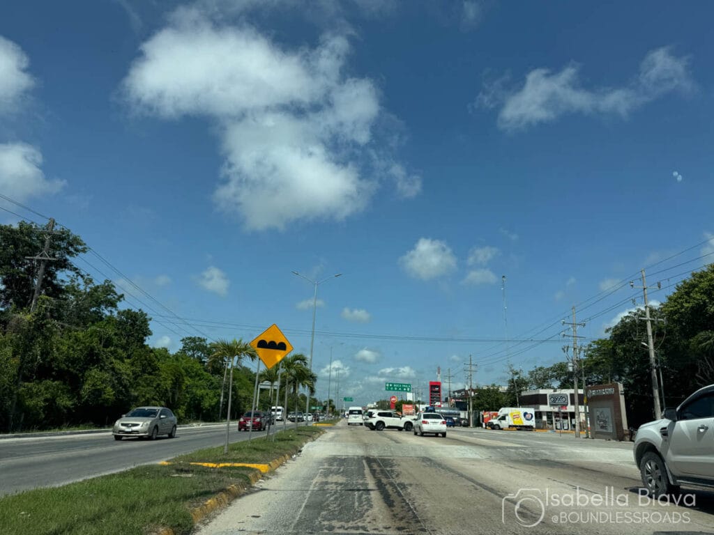 Highway with speed bumps sign and cars